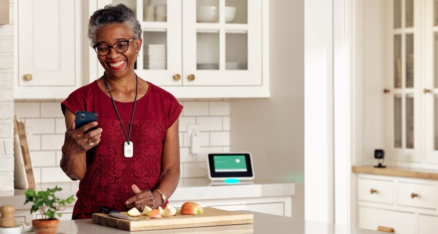 Woman in kitchen wearing a Vivint emergency medical pendant